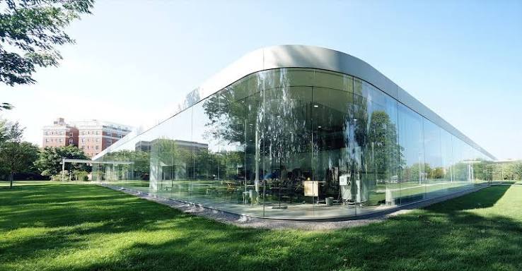 Het ronde glazen gebouw van het 21st Century Museum in het gras