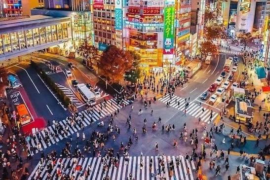 Het kruispunt van Shibuya van bovenaf, vol mensen en lichtreclames